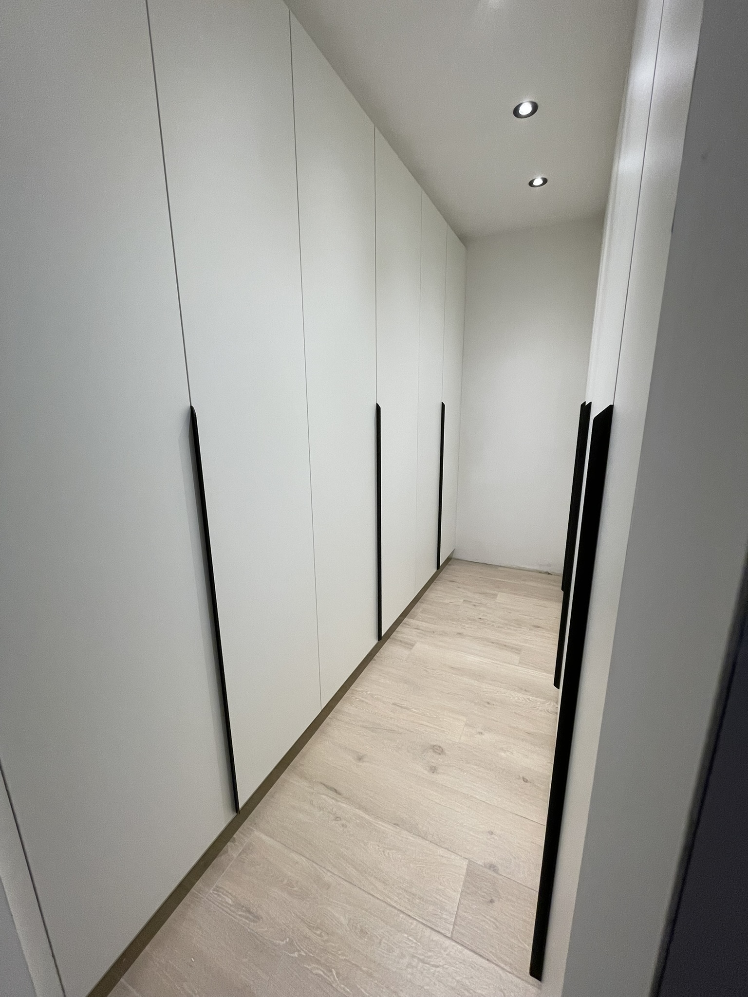 Fronten met lange zwarte grepen in de dressing in mat wit