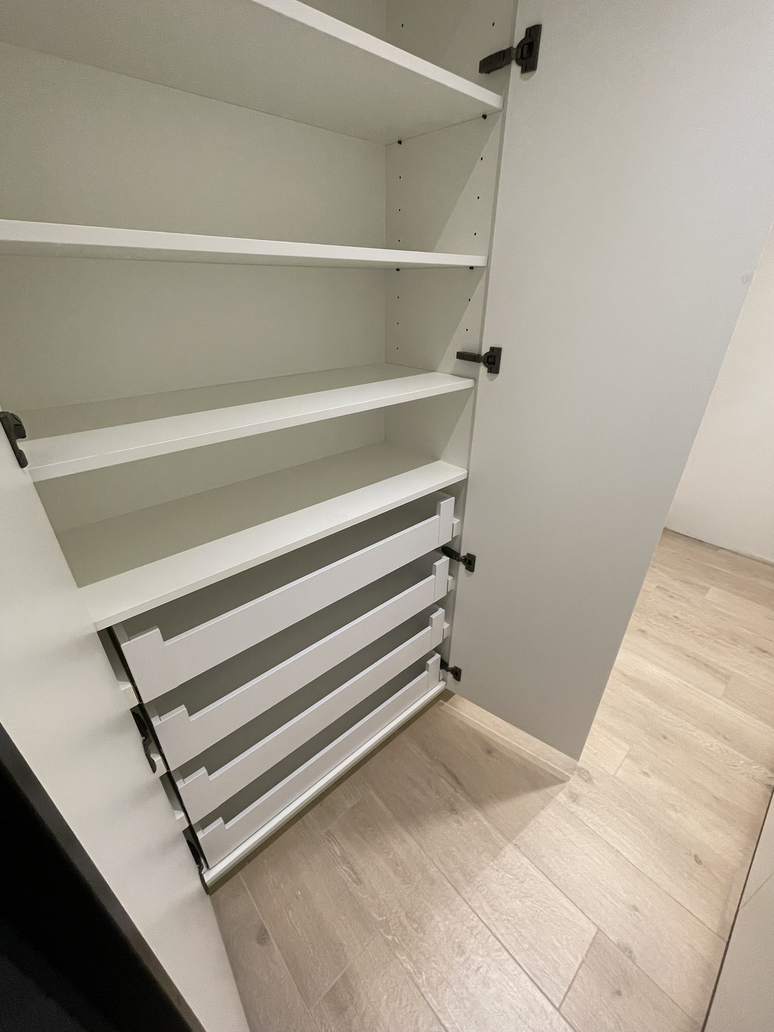 Indeling op maat van de garderobe in de dressing in mat wit