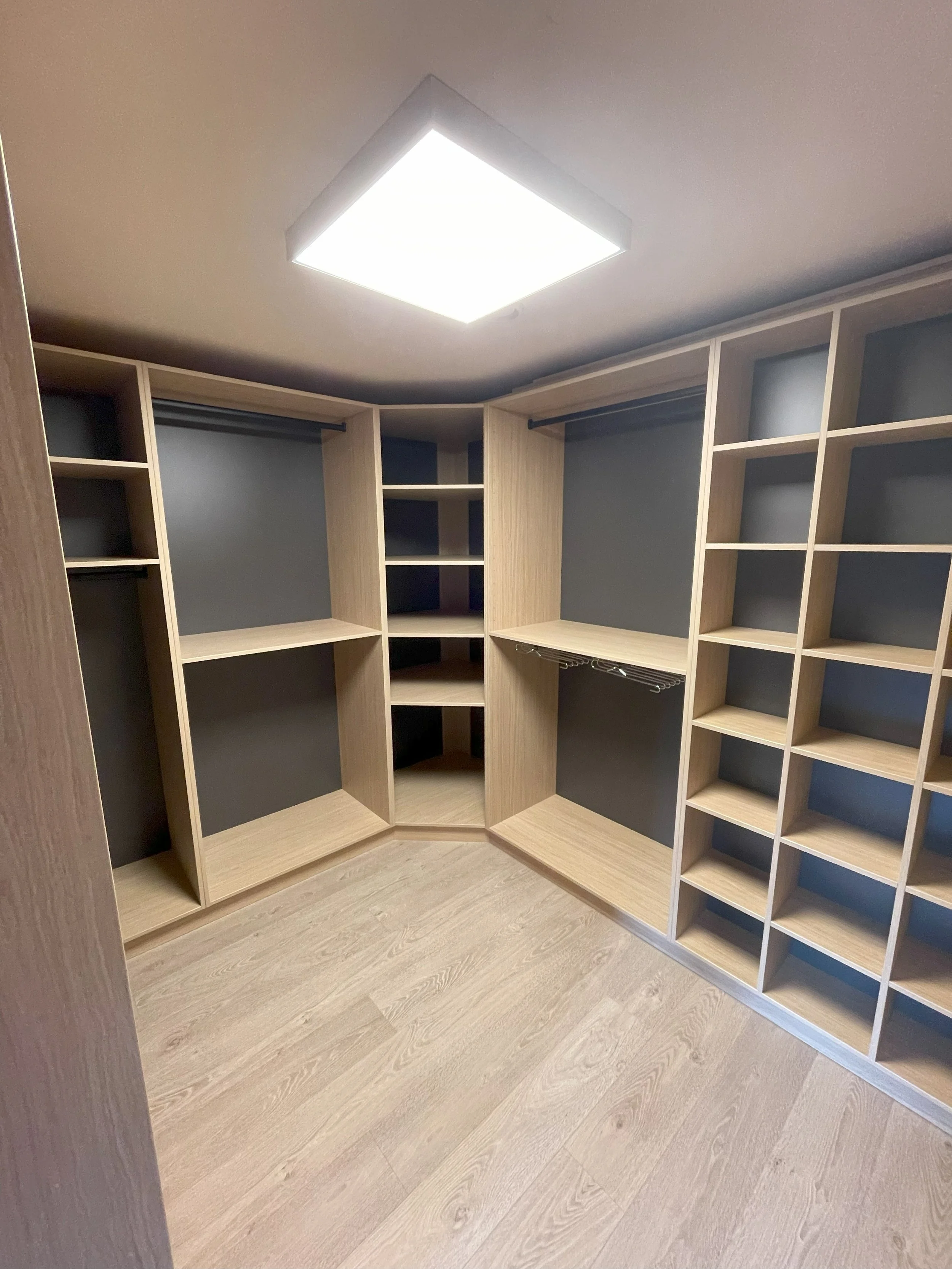 Open vakken en roedes in de inloopdressing in houtdecor melamine