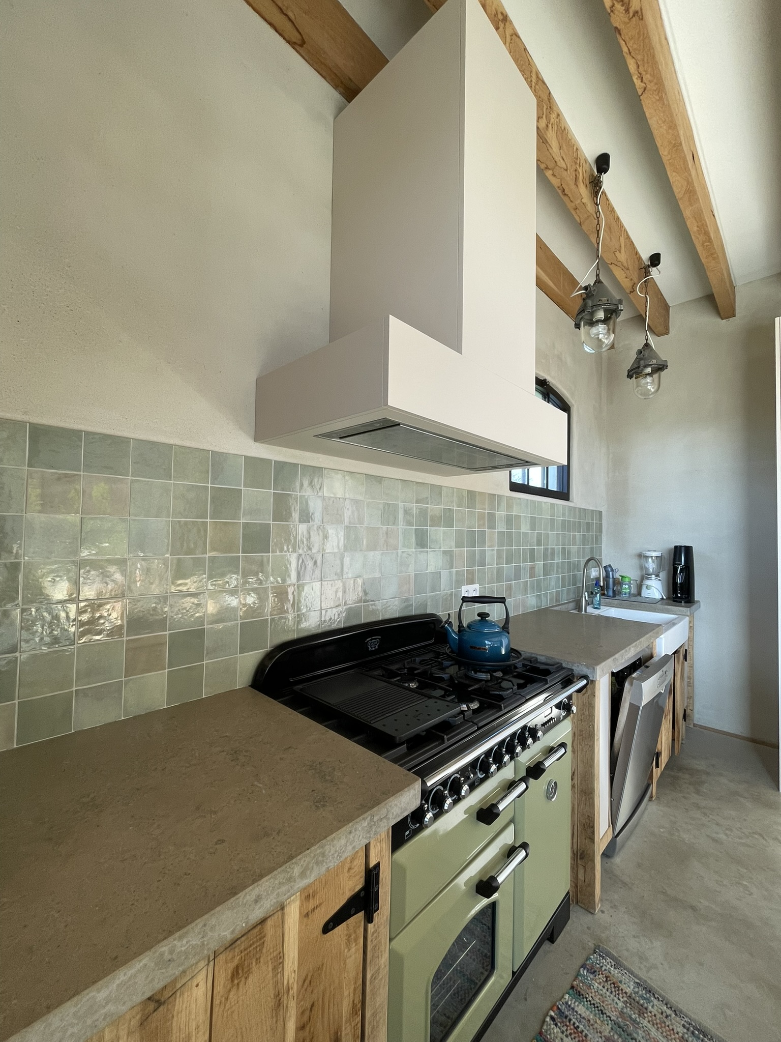 Dampkap-omkasting in beige melamine boven het bestaande fornuis in de keuken