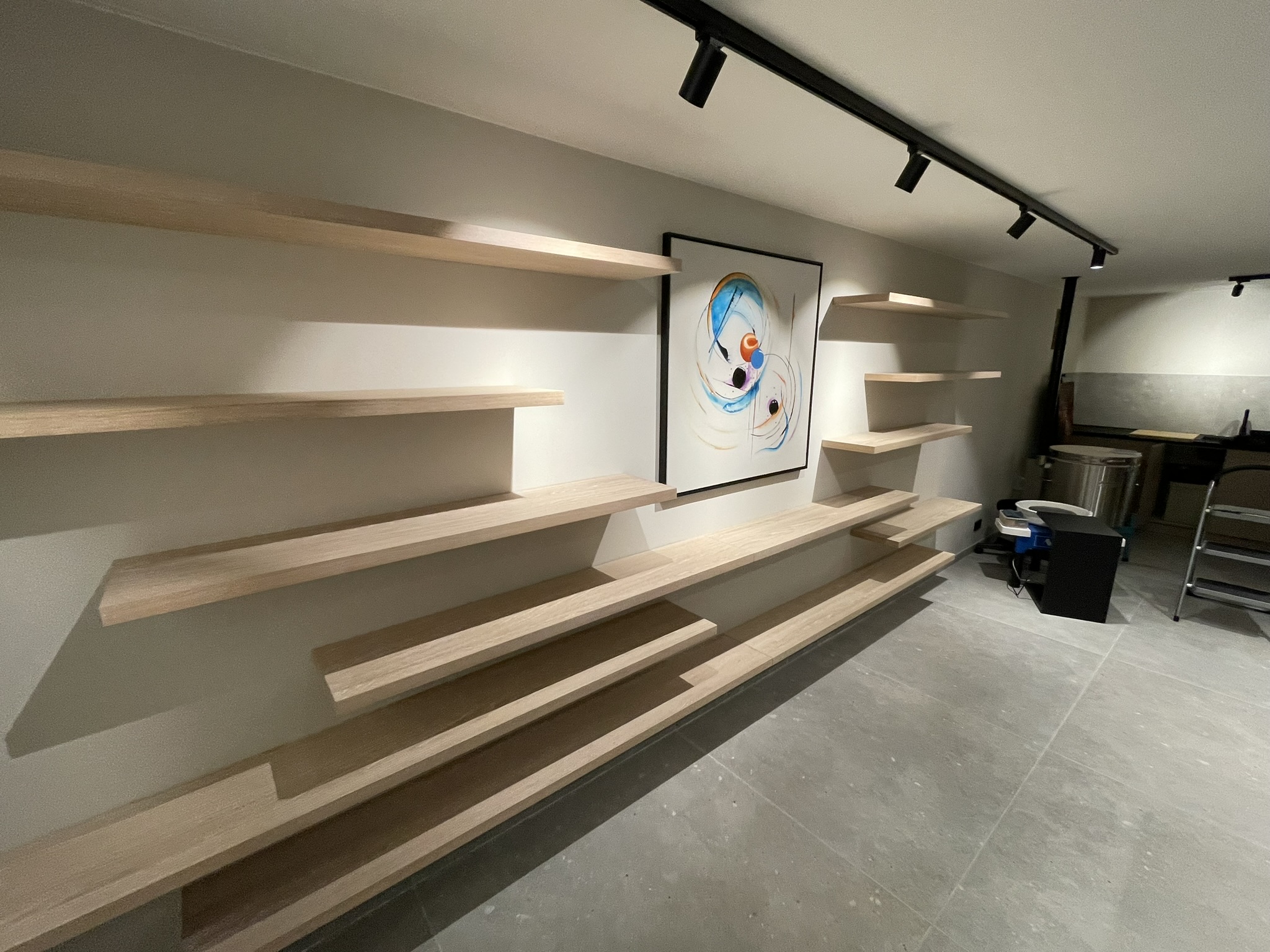 Massieve wandplanken in verspringende lengtes aan de wand van het keramiekatelier